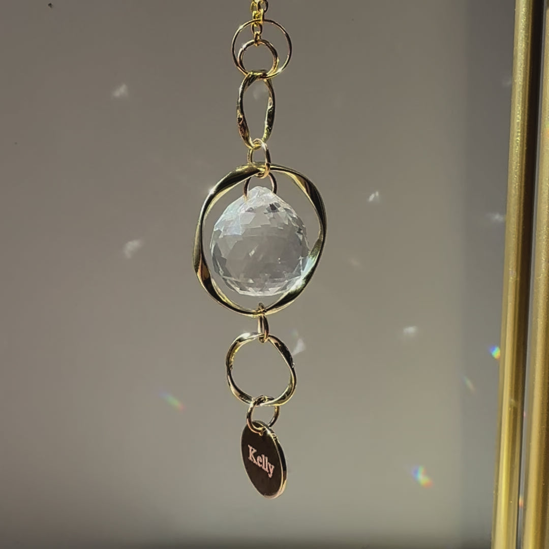 Video of the Custom Memorial Sun Catcher and Rainbow Maker with a personalized pendant at the bottom with the name "Kelly"