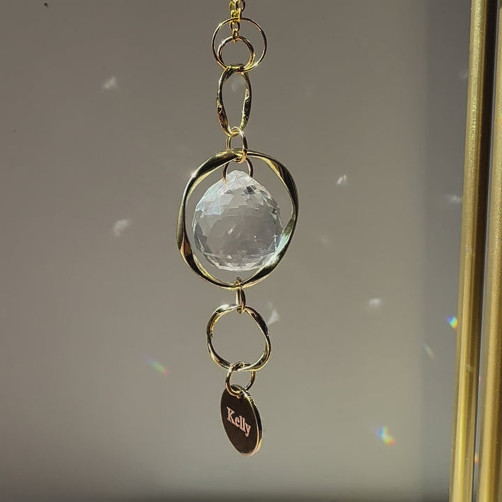 Video of the Custom Memorial Sun Catcher and Rainbow Maker with a personalized pendant at the bottom with the name "Kelly"