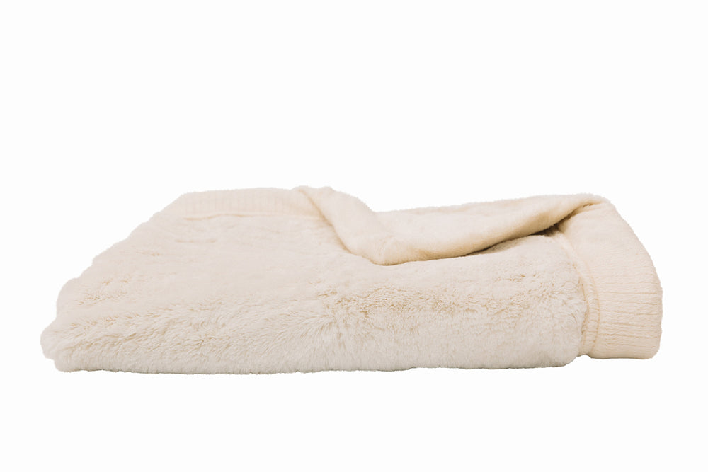 A close-up of a folded white fuzzy blanket.