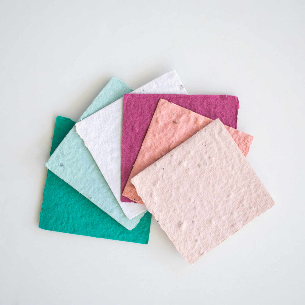 photo of square pieces of paper fanned out on a flat surface in multiple colors