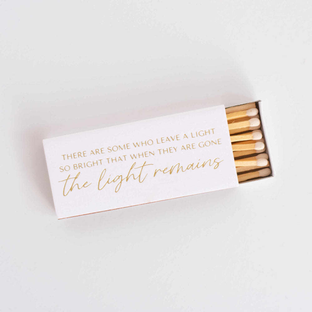 A tilted open box of matches with gold text on it.