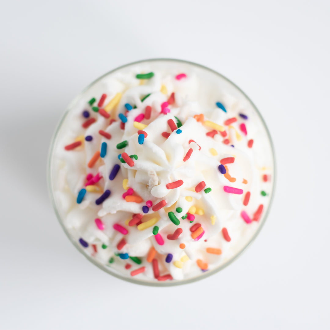 Overshot view looking down at a glass candle with sprinkles.