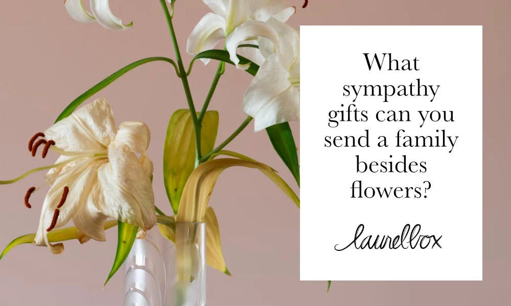 White lilies in a glass vase against a pink background, with text: What sympathy gifts can you send a family besides flowers?