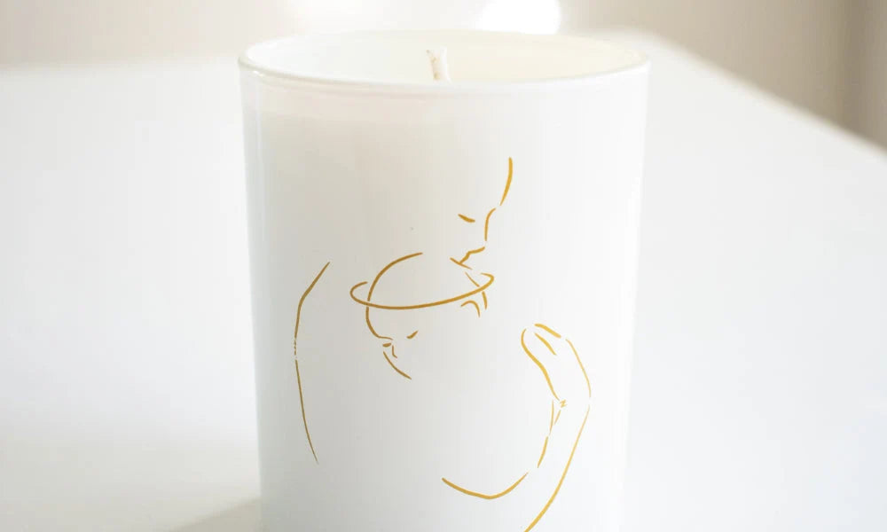 White candle with gold outline of a mother holding a child, symbolizing Care For a Grieving Mother With Miscarriage Gifts.