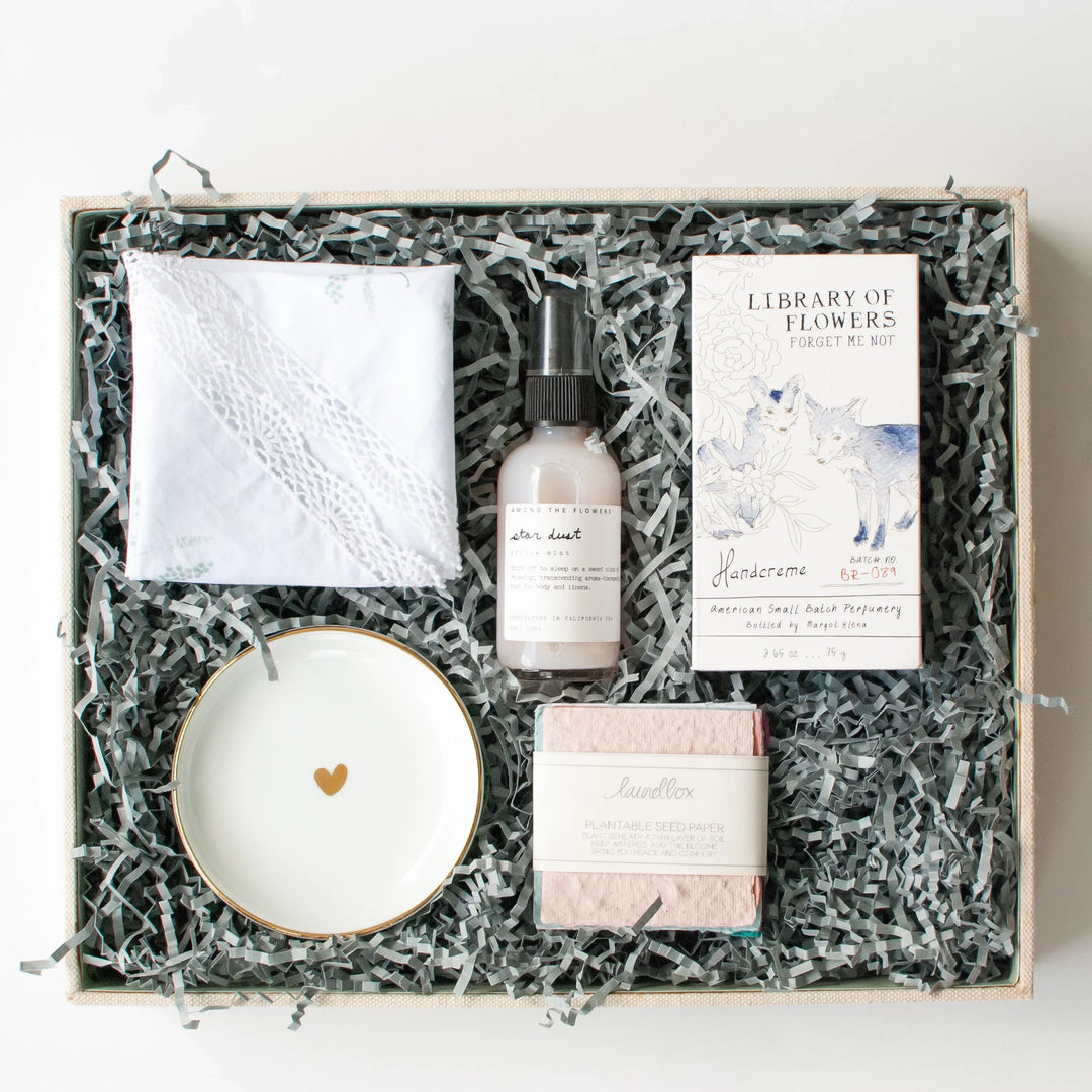 Building a laurelbox with a heart dish, floral card, hand mist, and pink soap in shredded paper.
