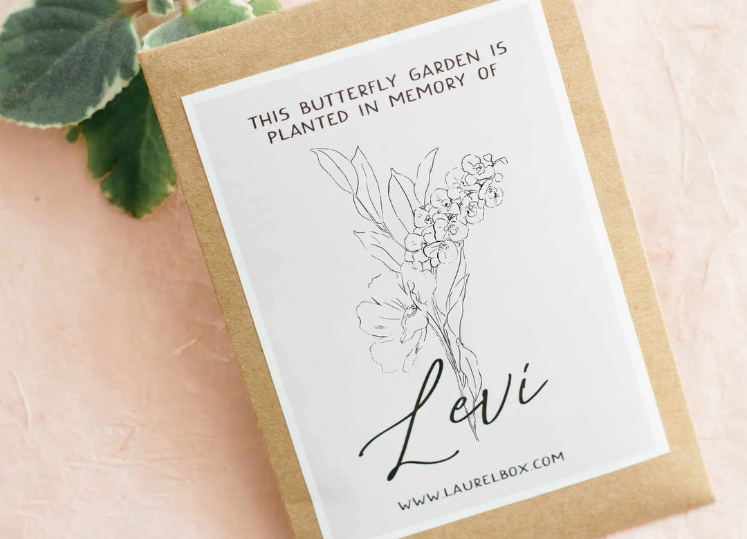 Butterfly garden seed packet with floral illustration and text 'This butterfly garden is planted in memory of Levi'. Brown kraft paper.