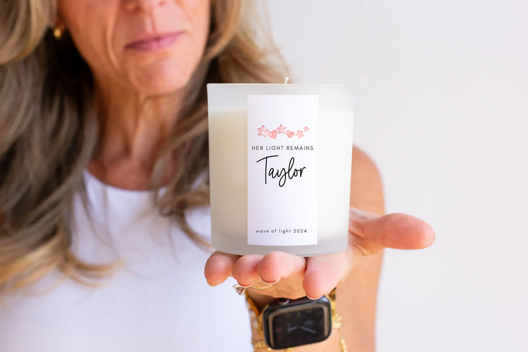 Candle in a person's hand, white with label reading 'Her Light Remains Taylor' and 'wave of light 2024'. The Importance of Reflection During Pregnancy & Infant Loss Awareness Month.