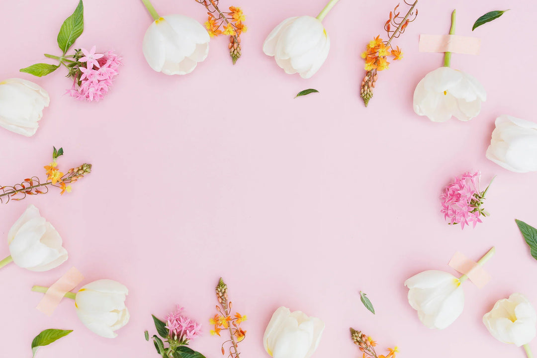 White tulips and assorted small flowers arranged on pink background, representing ideas for remembrance gifts. How to Handle Special Occasions After the Loss of a Loved One.
