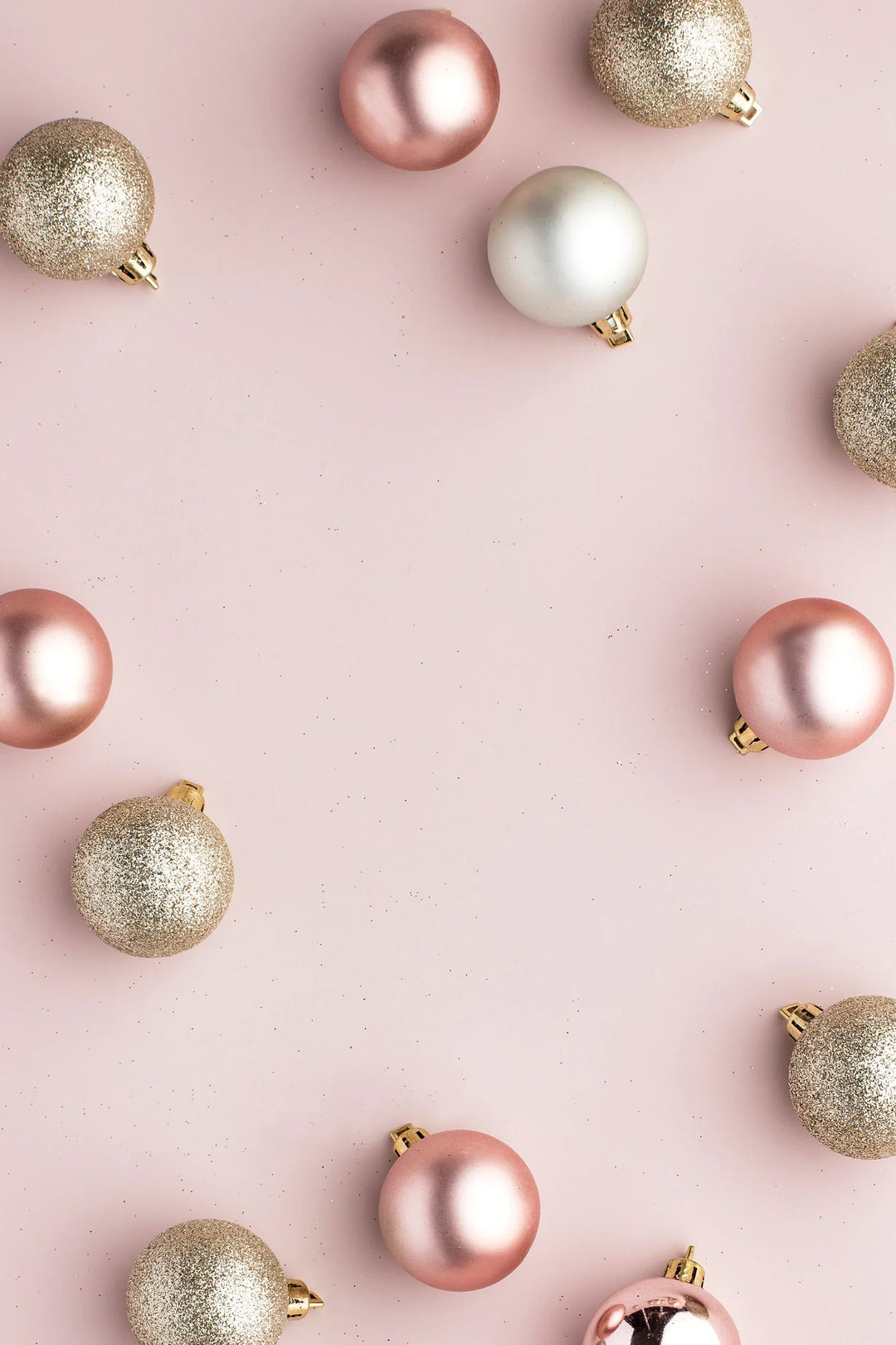 Spending The Holidays Away From Your Family: A Guide To Connection, featuring pink and gold Christmas ornaments on a light pink background.