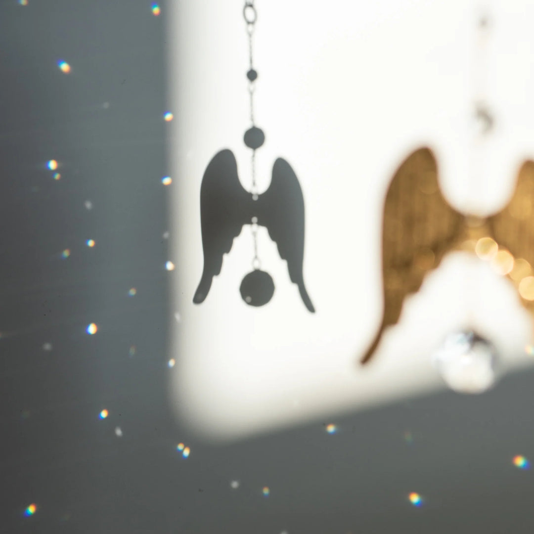 When Mother's Day Looks Different for a Loved One: silver angel wings casting a shadow with sparkling light reflections.