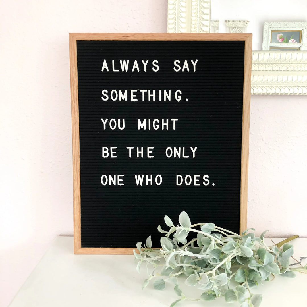 A framed letter board with the text "Always say something. You might be the only one who does." on a light background.