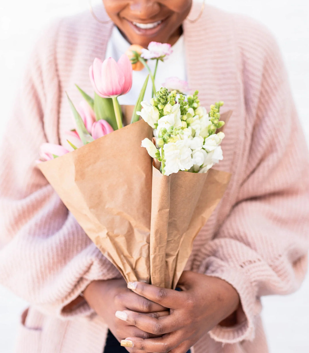 Valentine’s Day Remembrance: Gifts for Those Who Have Lost Their Partner. Pink tulips and white flowers wrapped in brown paper.