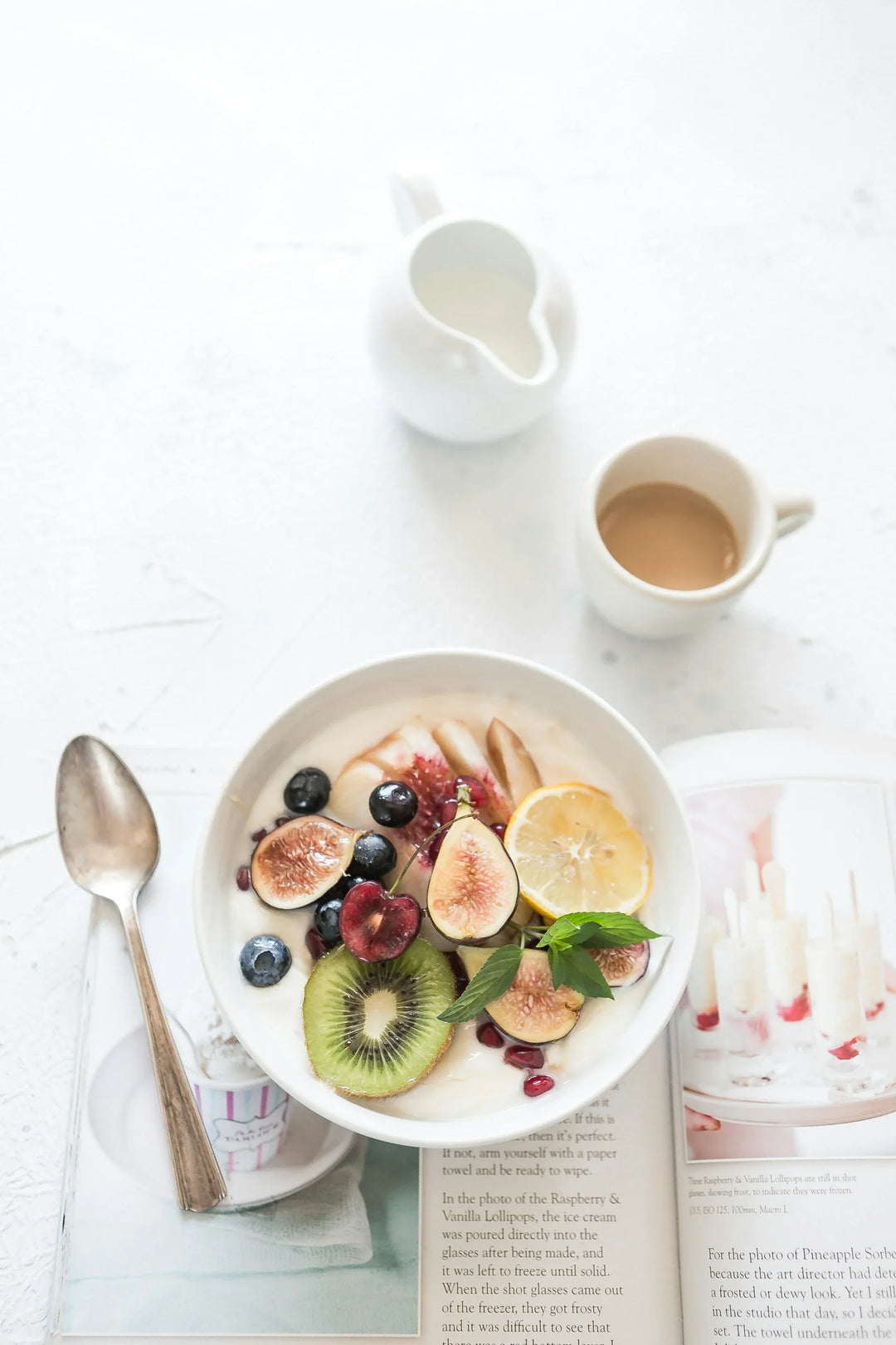 Self-Care To Help Beat The Post-Holiday Blues: a bowl of yogurt topped with fresh figs, kiwi, blueberries, and a slice of lemon.