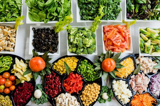 Meals To Send Someone Who Is Grieving: Ideas & Considerations. Colorful salad ingredients arranged in bowls, including greens, veggies, and toppings.