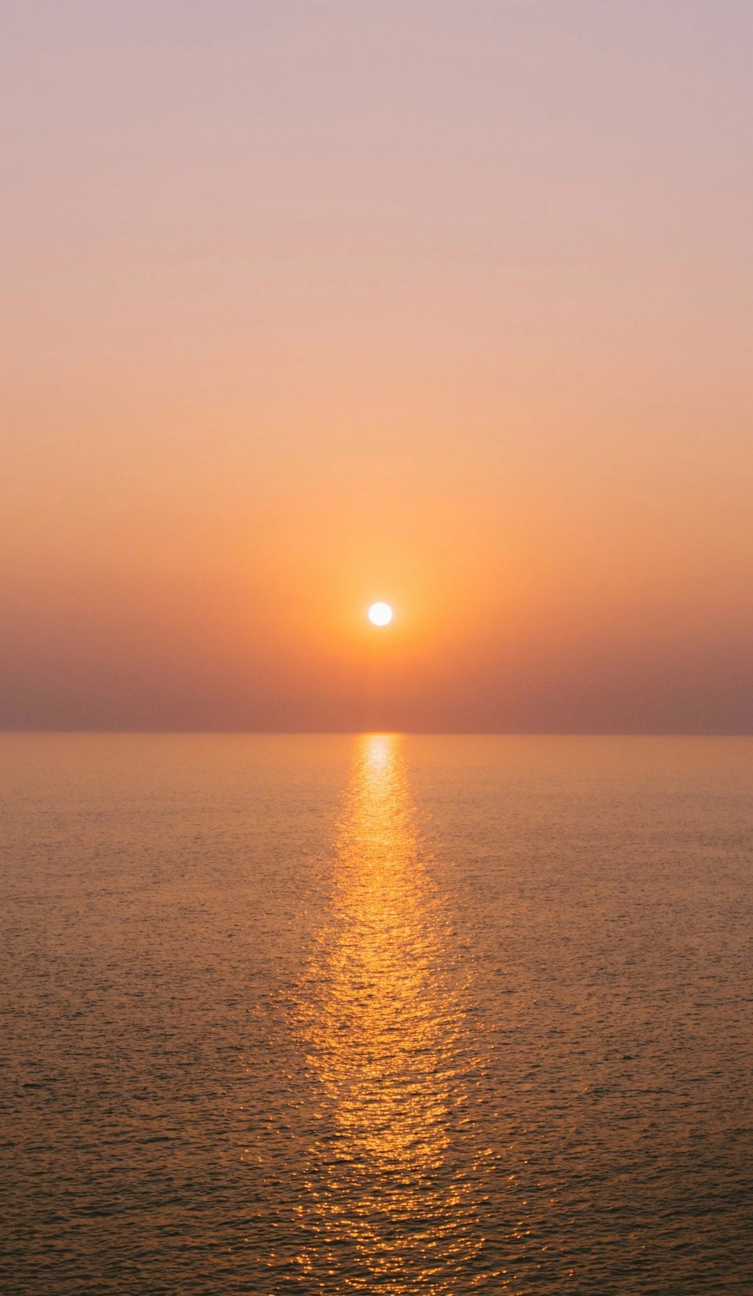 Sunset over the ocean reflecting golden light, illustrating the benefits of getting fresh air & sunshine when grieving.