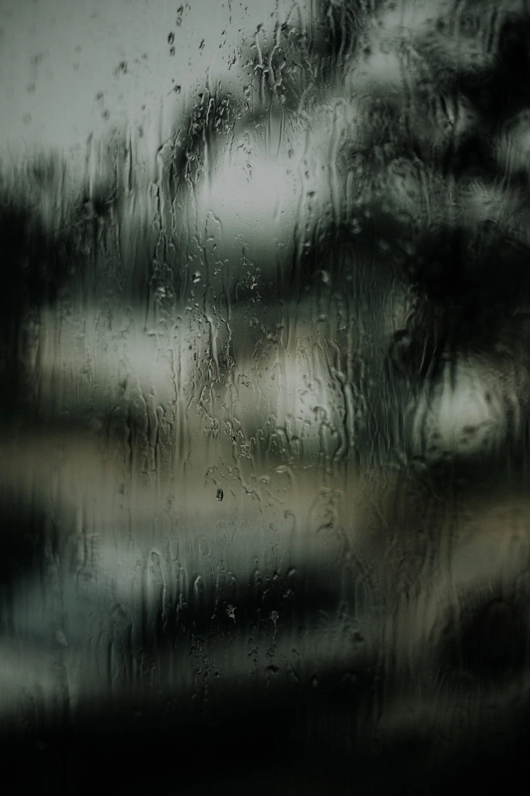 Navigating the Complex Path of Grief: Healing from Hurtful Relationships, a rain-streaked window with blurred view outside.