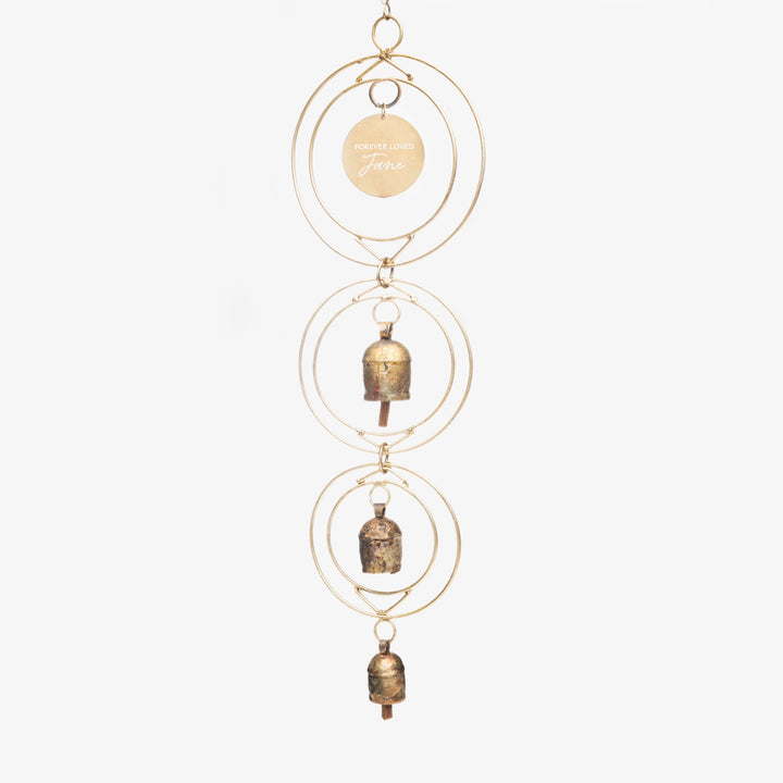 Custom Remembrance Wind Chime with three brass bells and a gold circular frame, engraved tag reading "Forever Loved Jane."