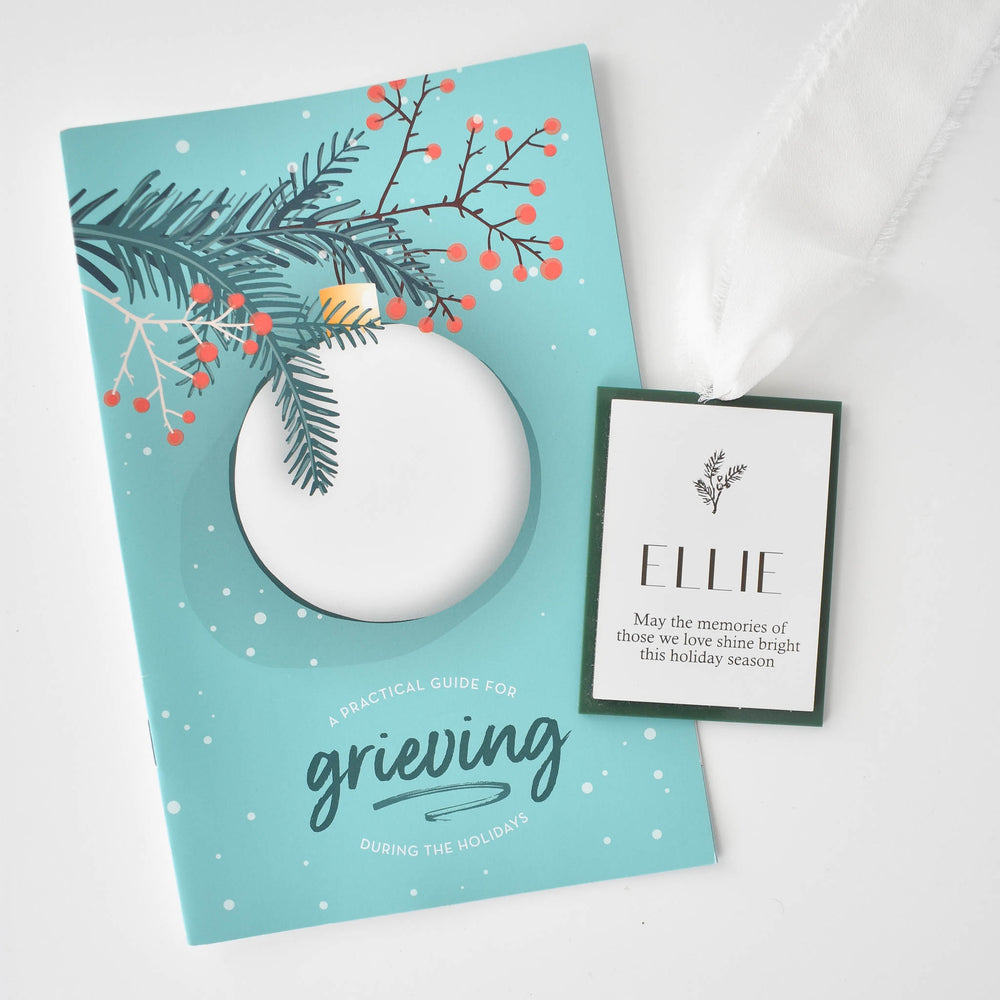 Memories Shine Bright Holiday Gift Box with a teal card showing a white ornament cutout and a tag reading 'ELLIE'.