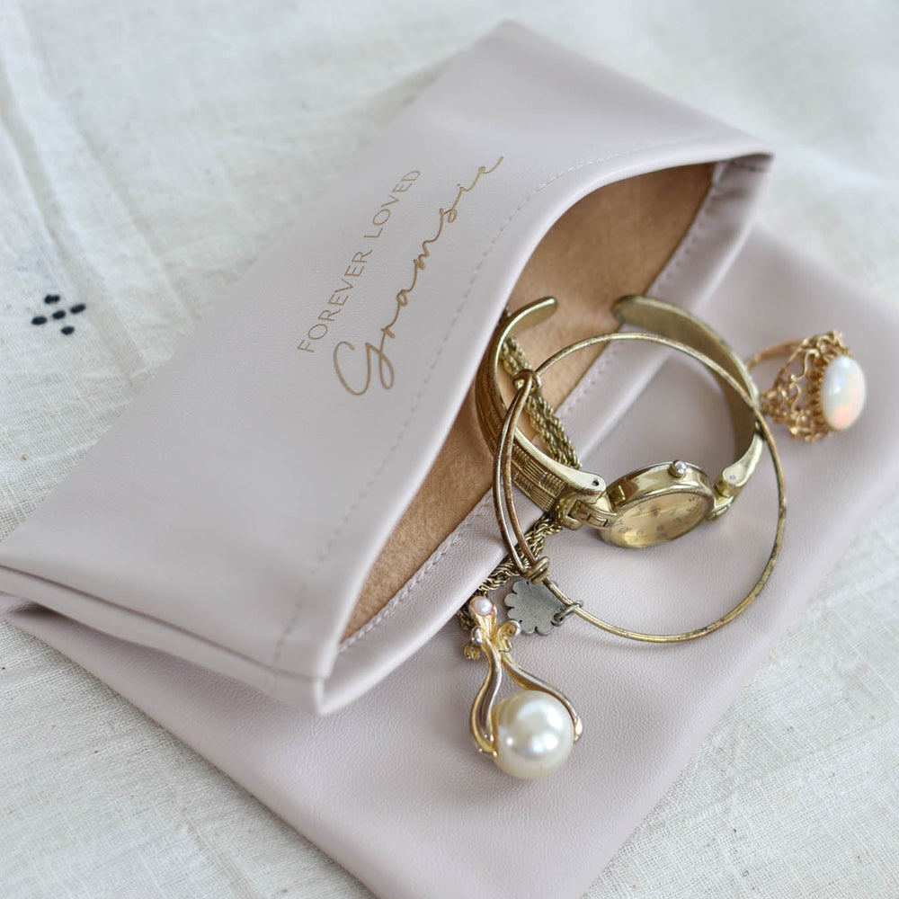 Personalized Memorial Clutch in light tan vegan leather with engraved "Forever Loved" and gold accessories inside.
