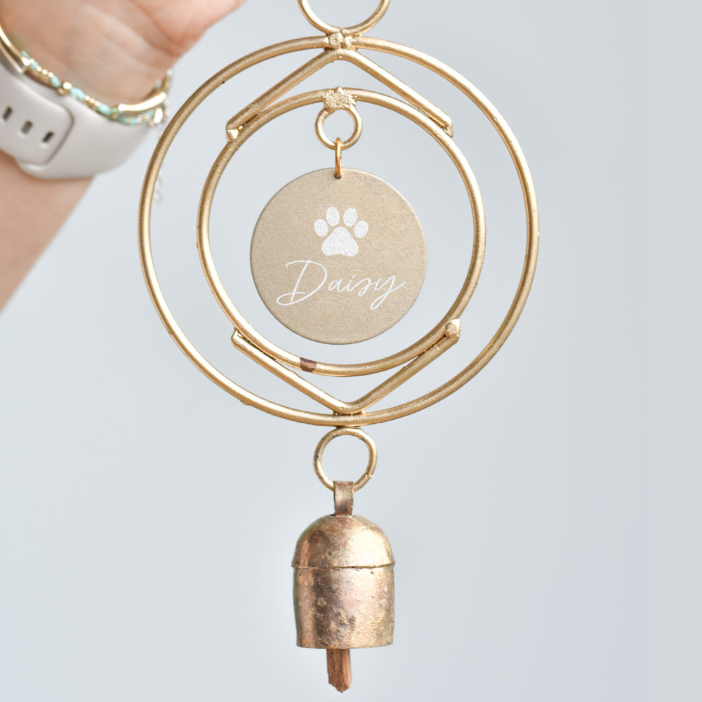 Dog Loss Wind Chime with gold circular frame, personalized round tag labeled 'Daisy', and small bronze bell.