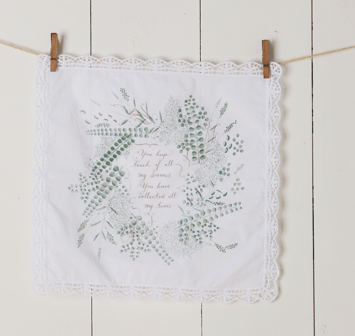 Collecting Your Tears Handkerchief with floral design, lace edges, white cotton fabric, and printed text in green and brown.