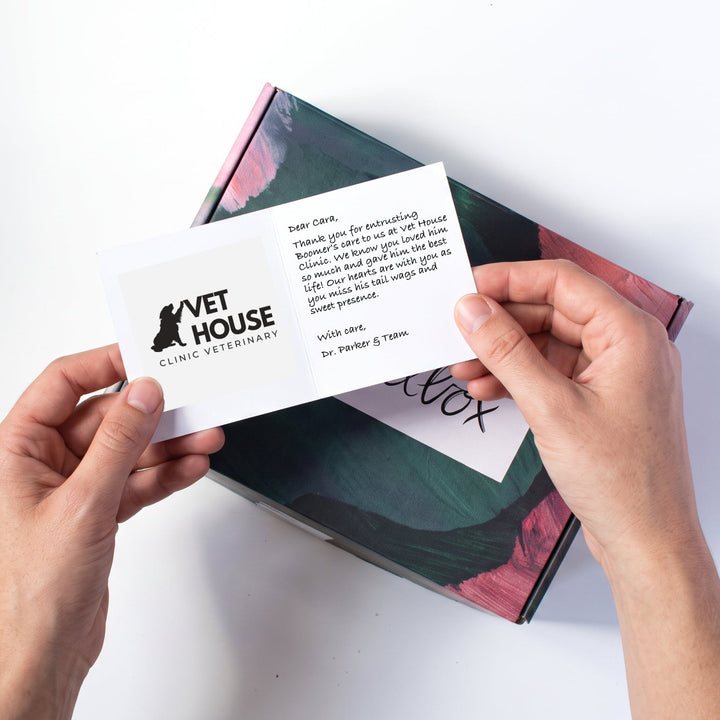 A card with a printed logo held above a laurelbox.