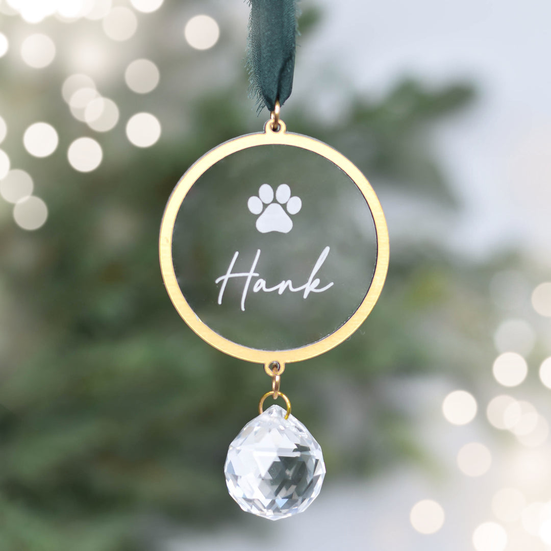 Pet Memorial Sun Catcher Ornament in gold with engraved paw print and name 'Hank', features a crystal prism below.