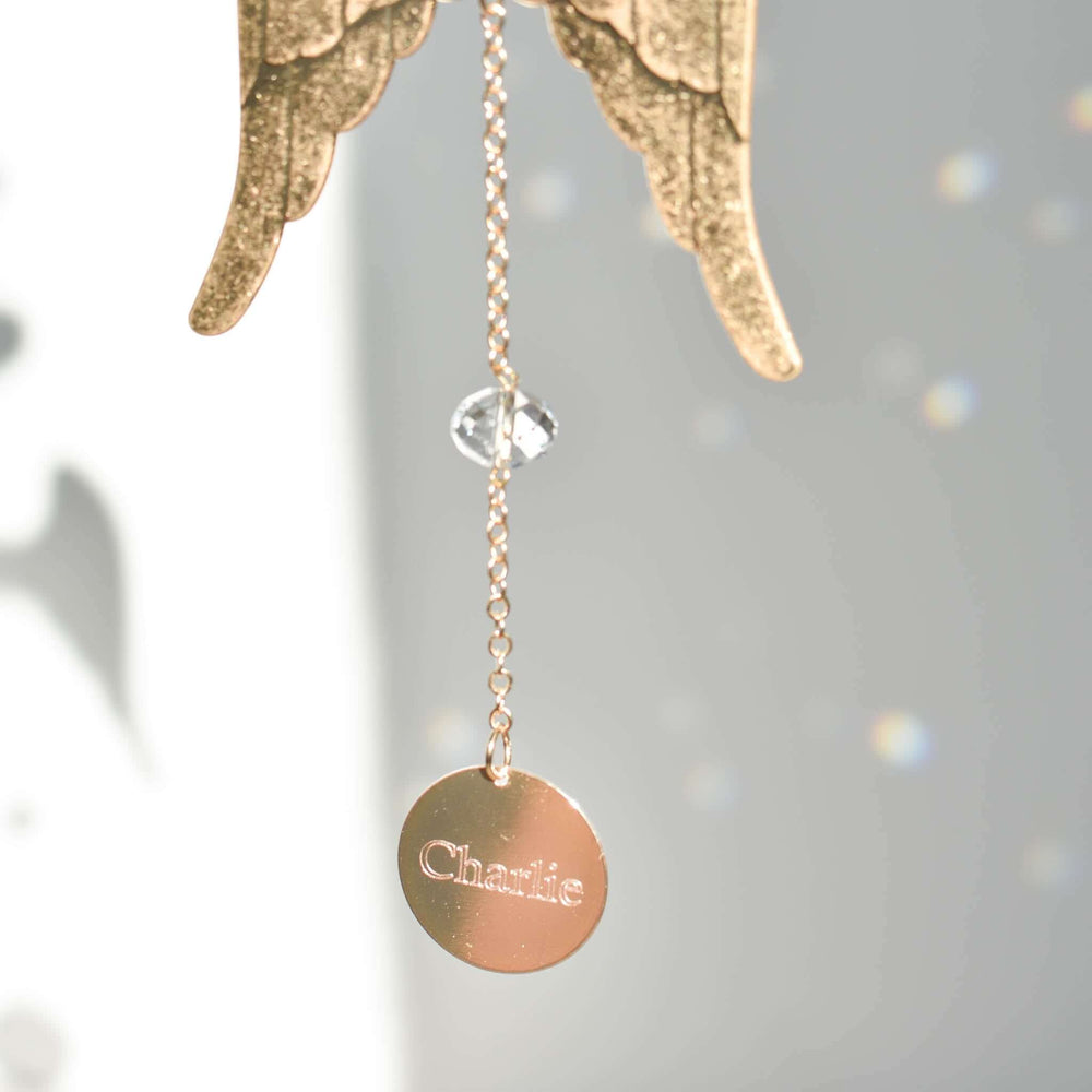 Angel Wing Sun Catcher & Rainbow Maker with gold wings, crystal bead, and engraved round tag with the name Charlie.