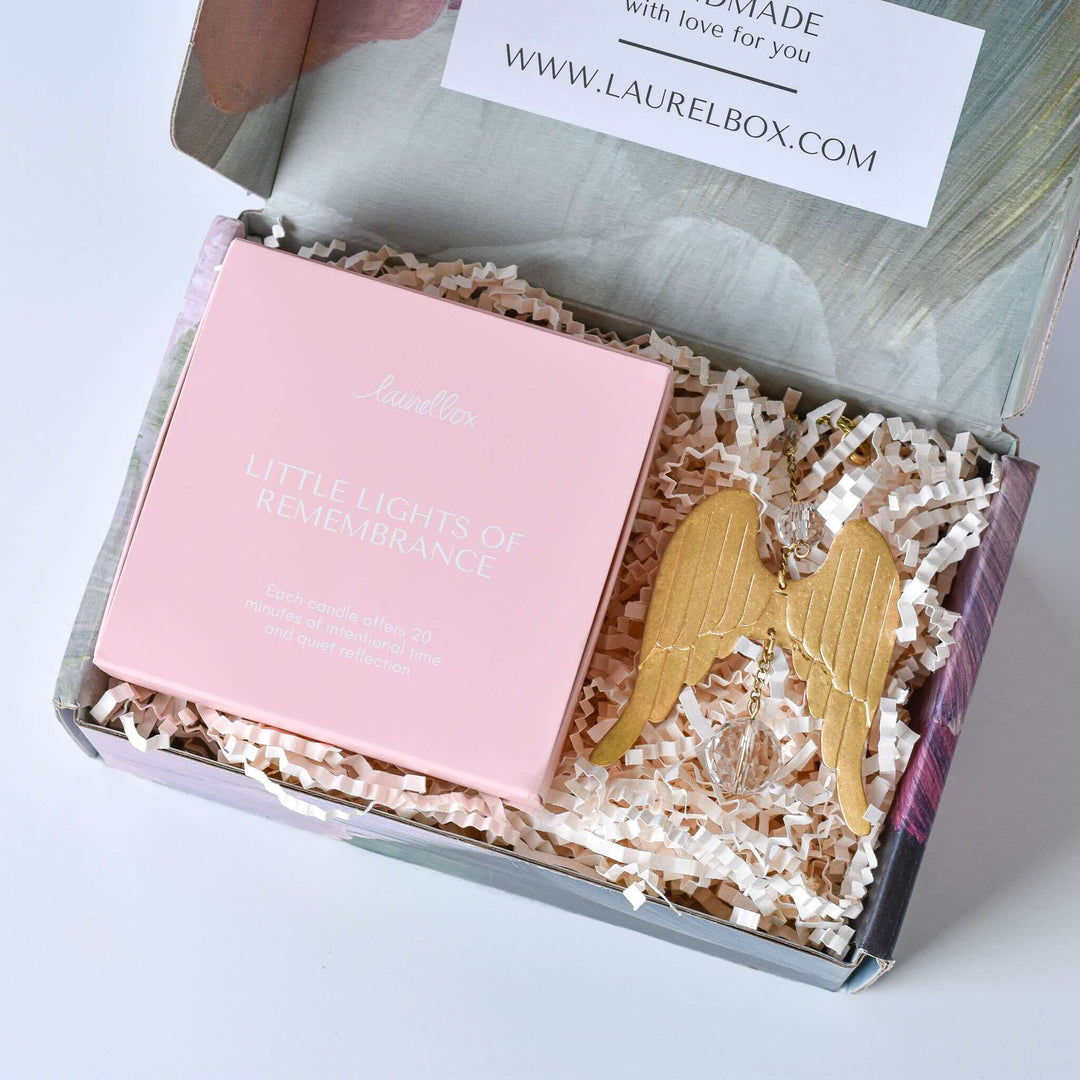 Light of an Angel gift box with a pink candle box labeled "Little Lights of Remembrance" and gold angel wing sun catcher.