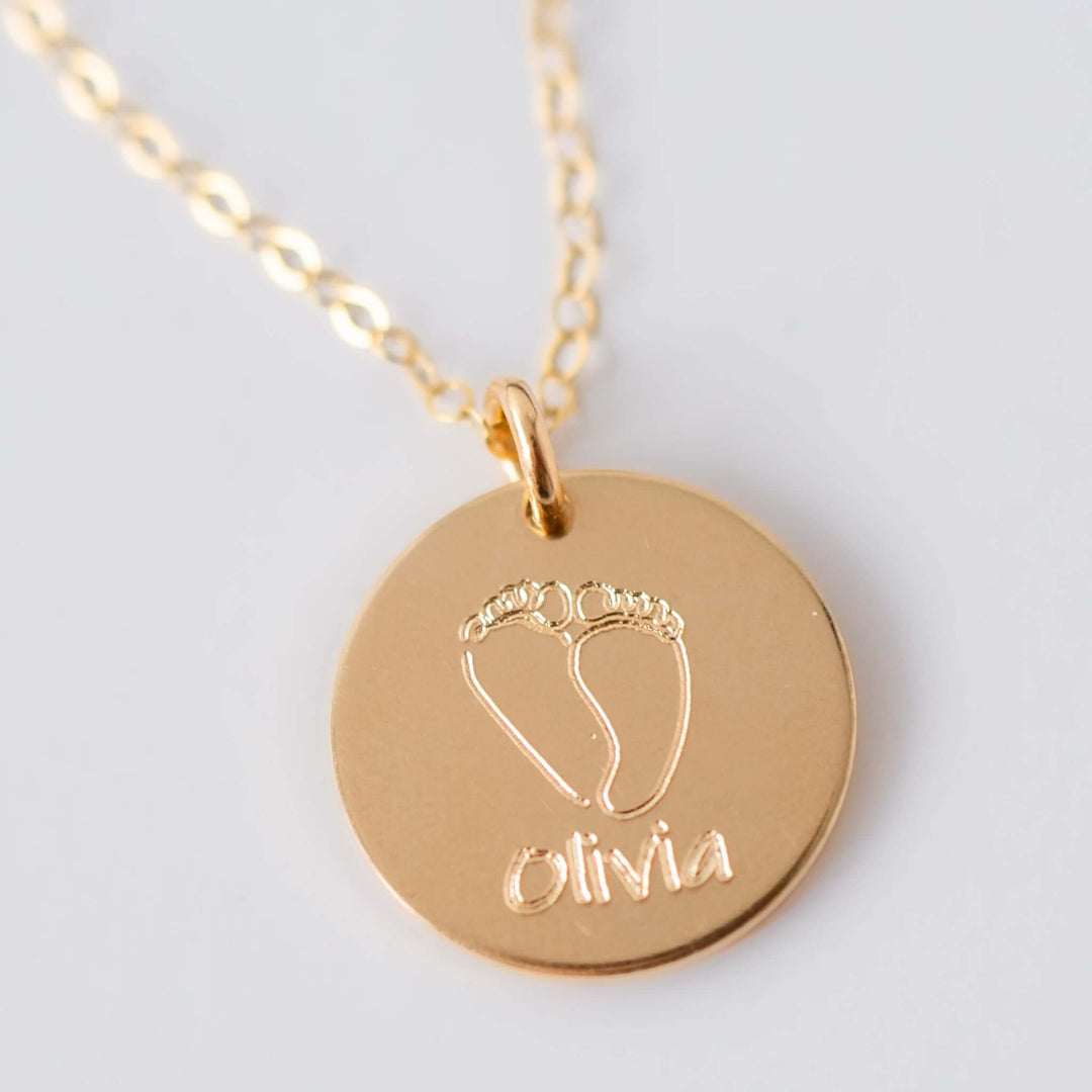Baby Footprints Necklace in gold, round charm with engraved baby feet and the name &