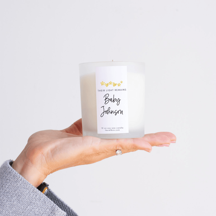 Child Loss Support Candle in a frosted glass container held in hand, featuring a white label with &