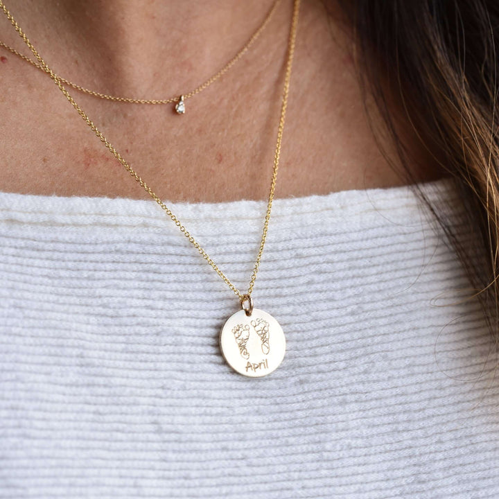Custom Handprint or Footprint Necklace with gold charm featuring engraved footprints and the name &