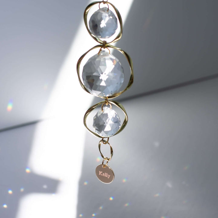 Light in Dark Places Gift Box includes a gold sun catcher with three clear crystal beads and an engraved tag that says &