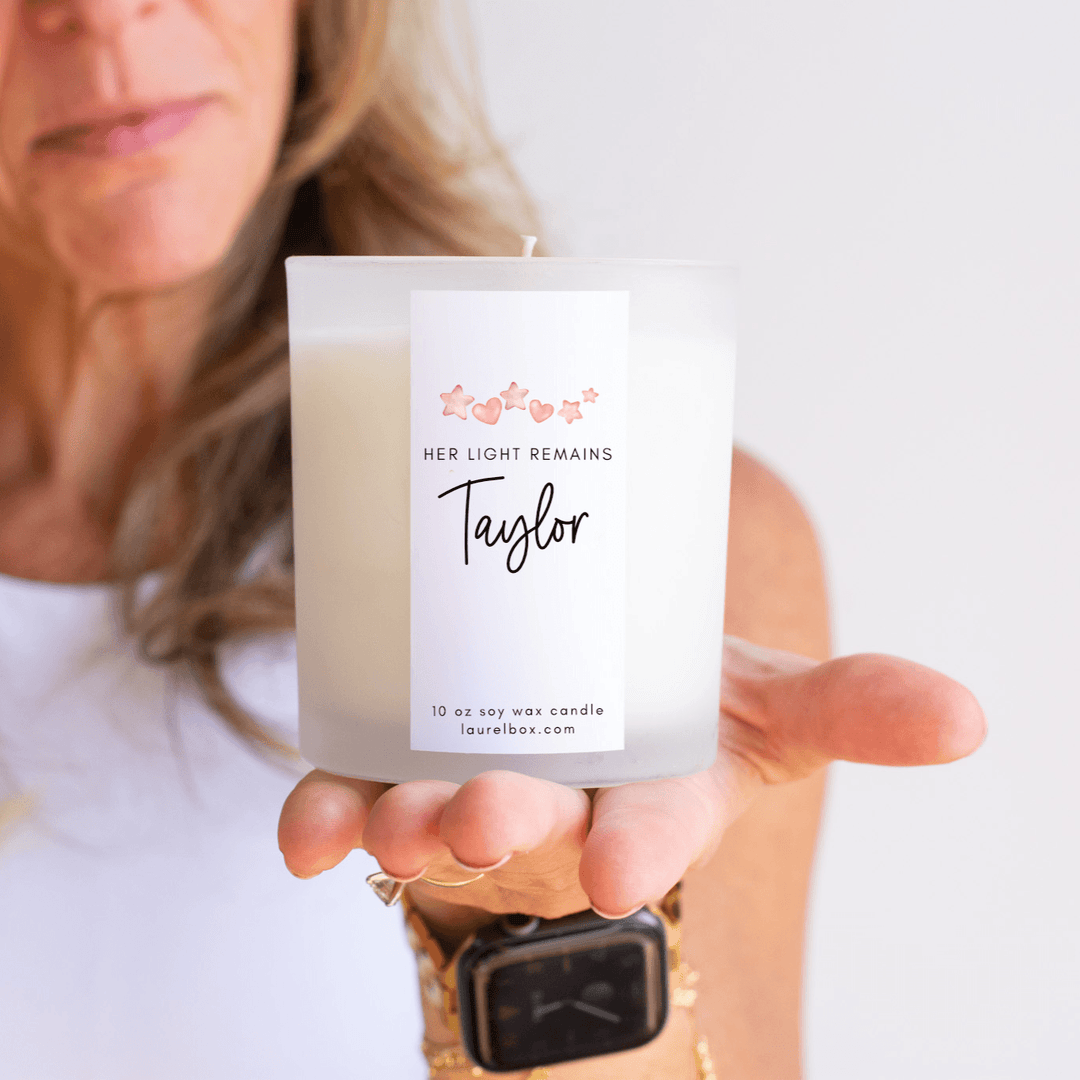 Child Loss Support Candle with white wax in a clear frosted glass holder, personalized label with name "Taylor" and floral design.