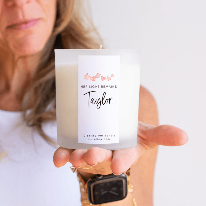 Child Loss Support Candle with white wax in a clear frosted glass holder, personalized label with name "Taylor" and floral design.