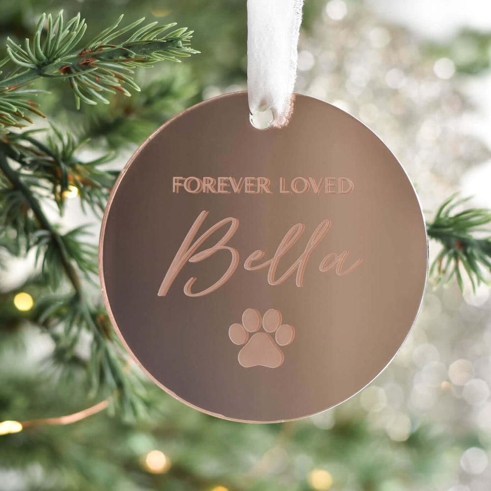 Custom Dog or Cat Memorial Ornament in rose gold acrylic with engraved text 'Forever Loved Bella' and a paw print shape.