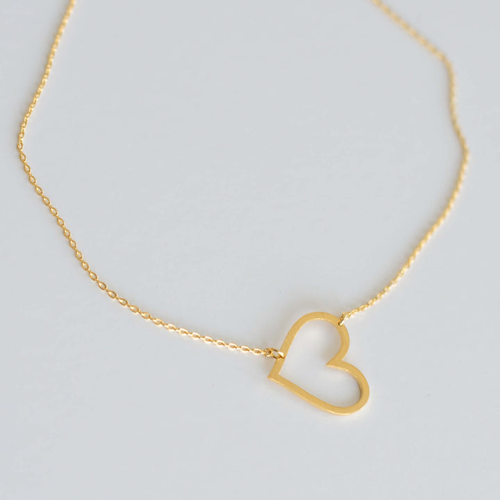 Heart to Heart Necklace in gold metal featuring an open heart design on a delicate chain, a unique remembrance gift.