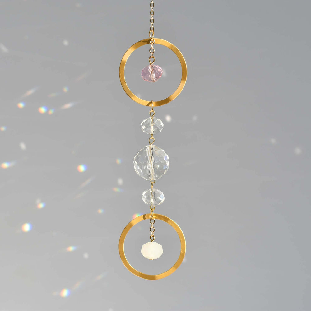 Memorial Birthstone Sun Catcher with gold circles and colored glass beads, suspended on a chain, against a gray background.