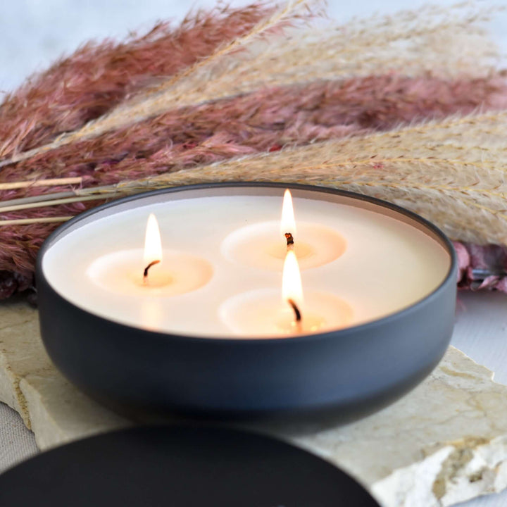 Morningside Employee Sympathy Gift includes a black bowl with three lit candles and pampas grass in the background.