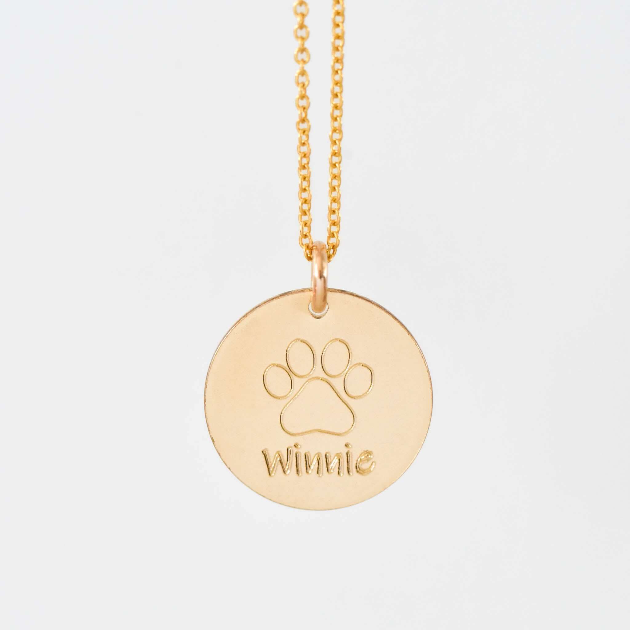 Personalized Pet Necklace featuring a gold filled charm with a paw print and the name 'Winnie' engraved on it.