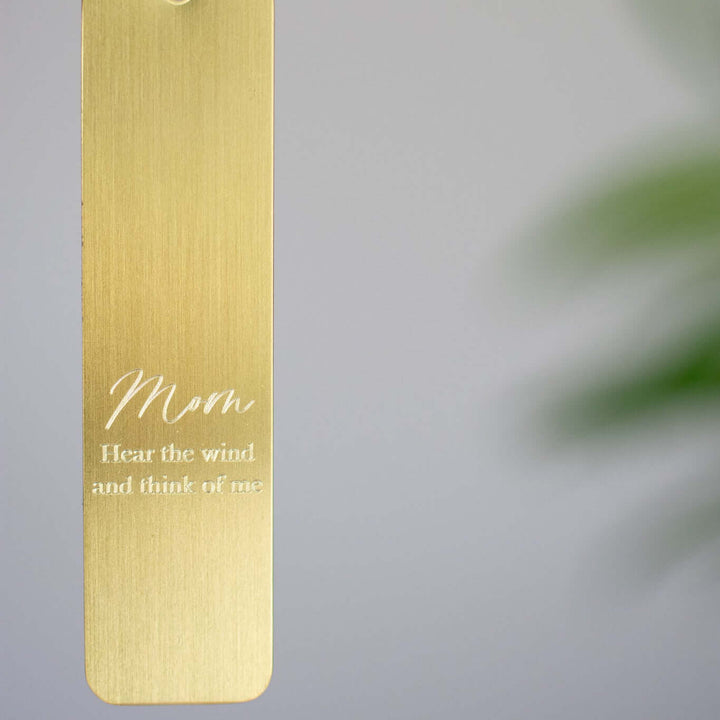 Memorial Wind Chime engraved metal tag in gold with text "Mom Hear the wind and think of me" in white.