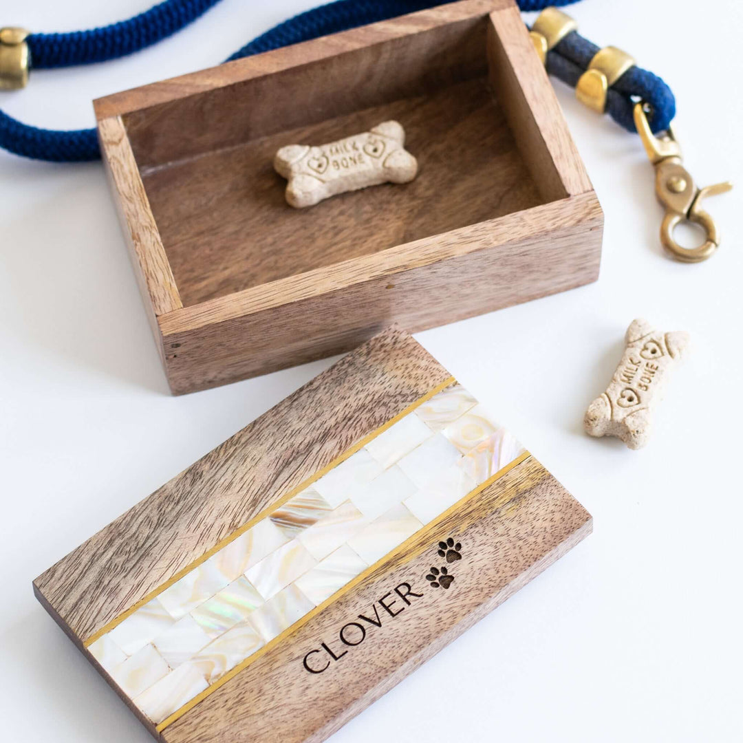 Pet Keepsake Memory Box made of mango wood with a mother of pearl inlay, engraved with 'CLOVER', and a pet treat bone inside.