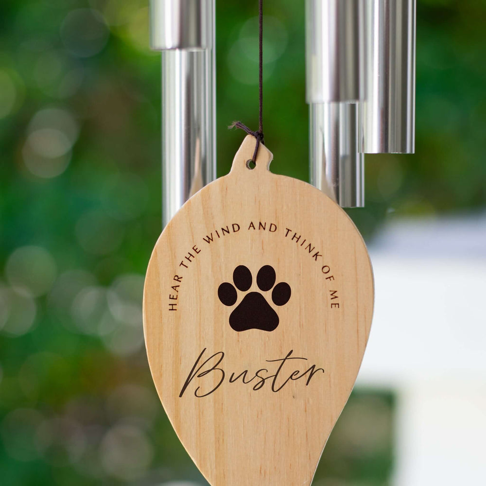 Pet Wind Chime features a wooden leaf-shaped tag engraved with "HEAR THE WIND AND THINK OF ME" and the name "Buster."