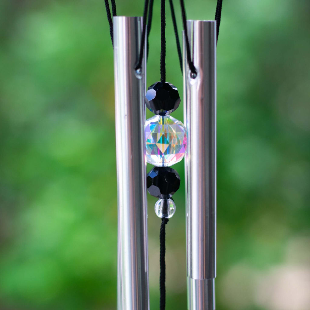 Close-up of the Rainbow Bridge Dog Wind Chime showing silver tubes and a rainbow charm with black beads.