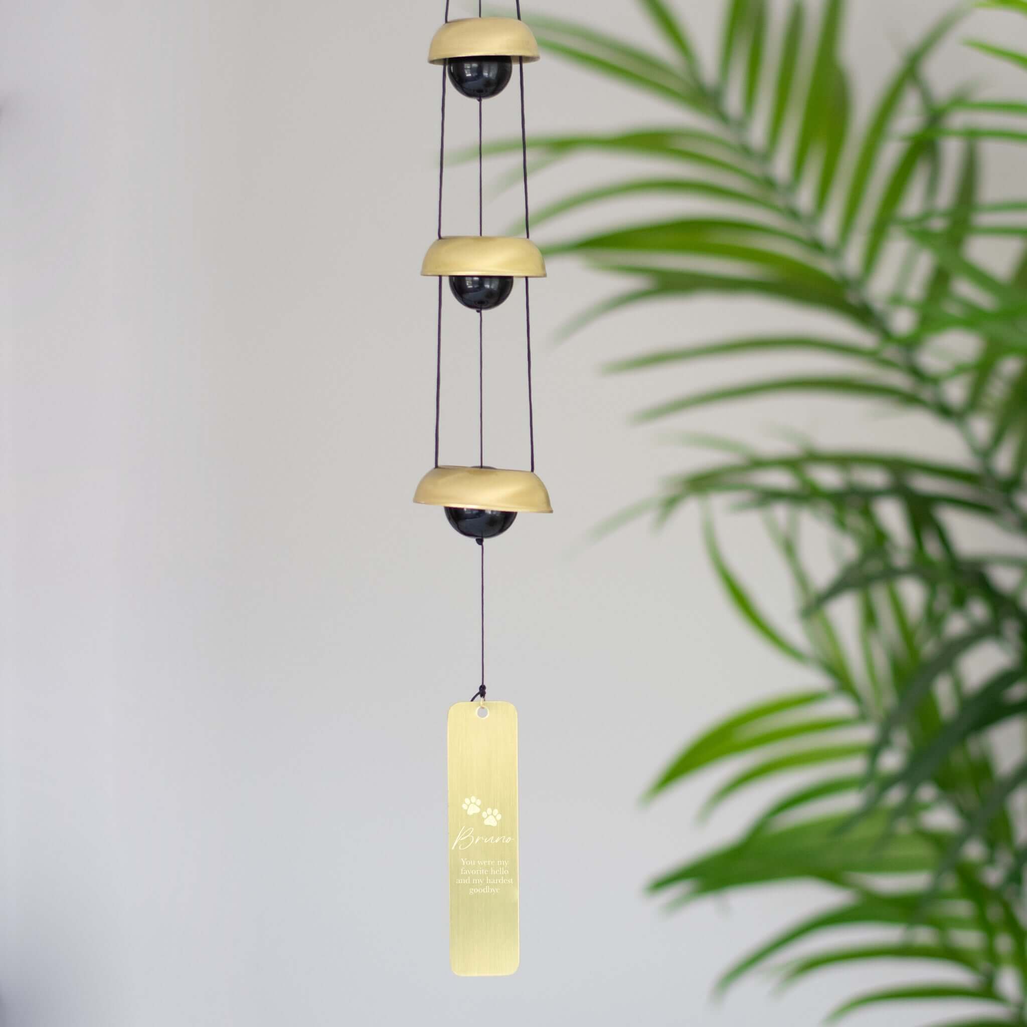 Rainbow Bridge Pet Memorial Box features a gold and black wind chime with a personalized plaque and paw print design.