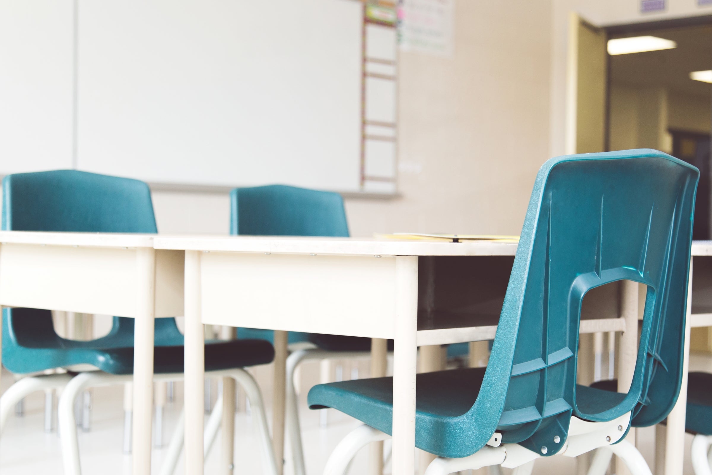 blue chairs sitting around white desks in a classroom 