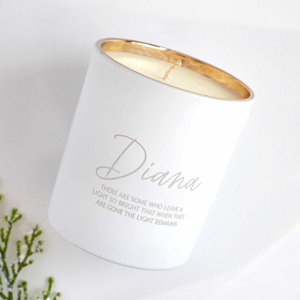 A white-coated candle with engraved text Diana There are some who leave a light so bright that when they are gone the light remains angled to the right against a white background