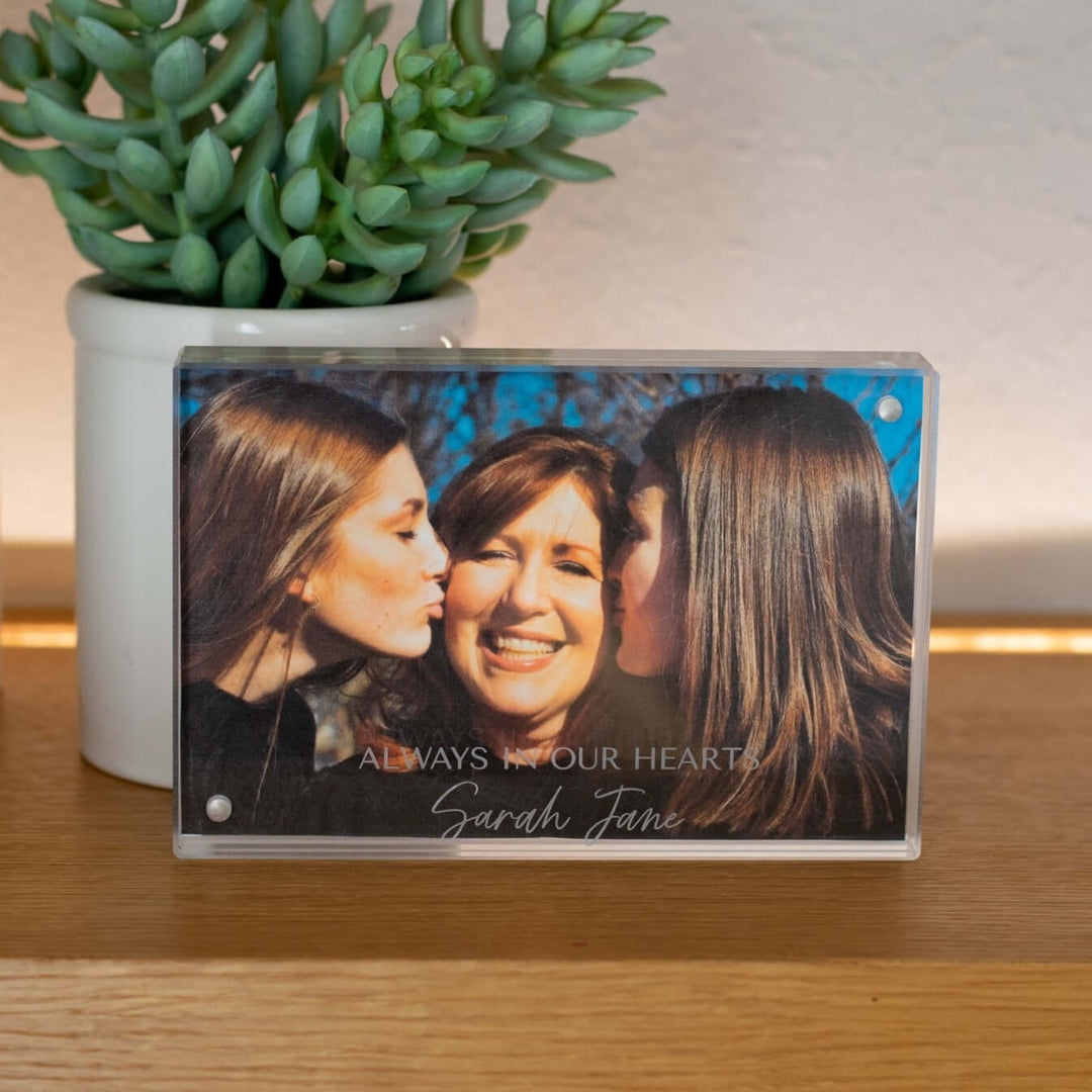 Custom Engraved Memorial Photo Frame made of clear acrylic displaying a photo with text 'ALWAYS IN OUR HEARTS Sarah Jane'.
