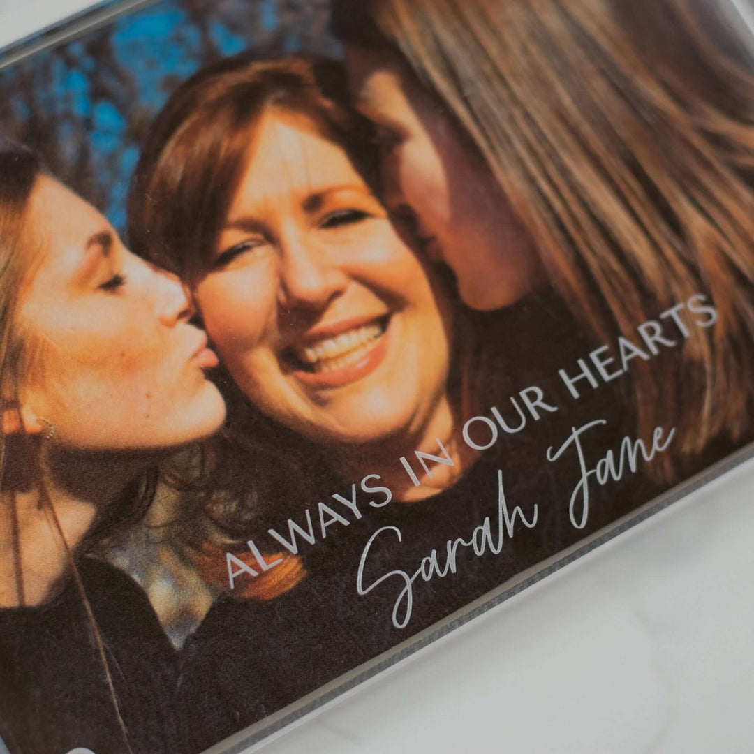 Custom Engraved Memorial Photo Frame featuring text "ALWAYS IN OUR HEARTS" and name "Sarah Jane" over a family photo.