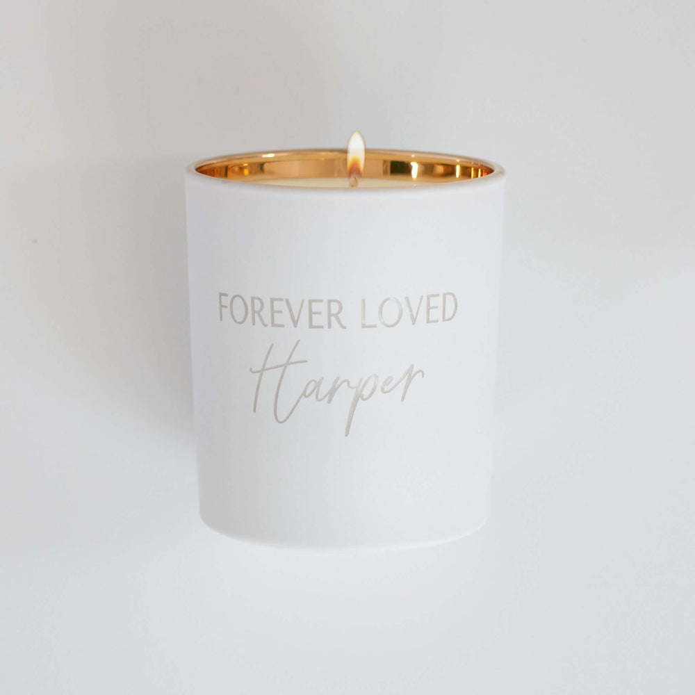 Forever Loved Custom Engraved Candle in white with gold rim, engraved text 'FOREVER LOVED Harper', lit wick, smooth finish.
